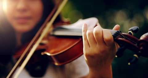 Jovem tocando violino ao ar livre em close-up