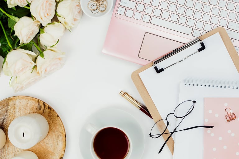 Stylish feminine workspace with laptop, tea, and roses