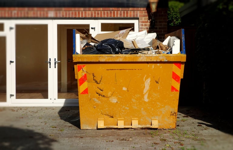 Yellow dumpster filled with renovation debris in residential driveway