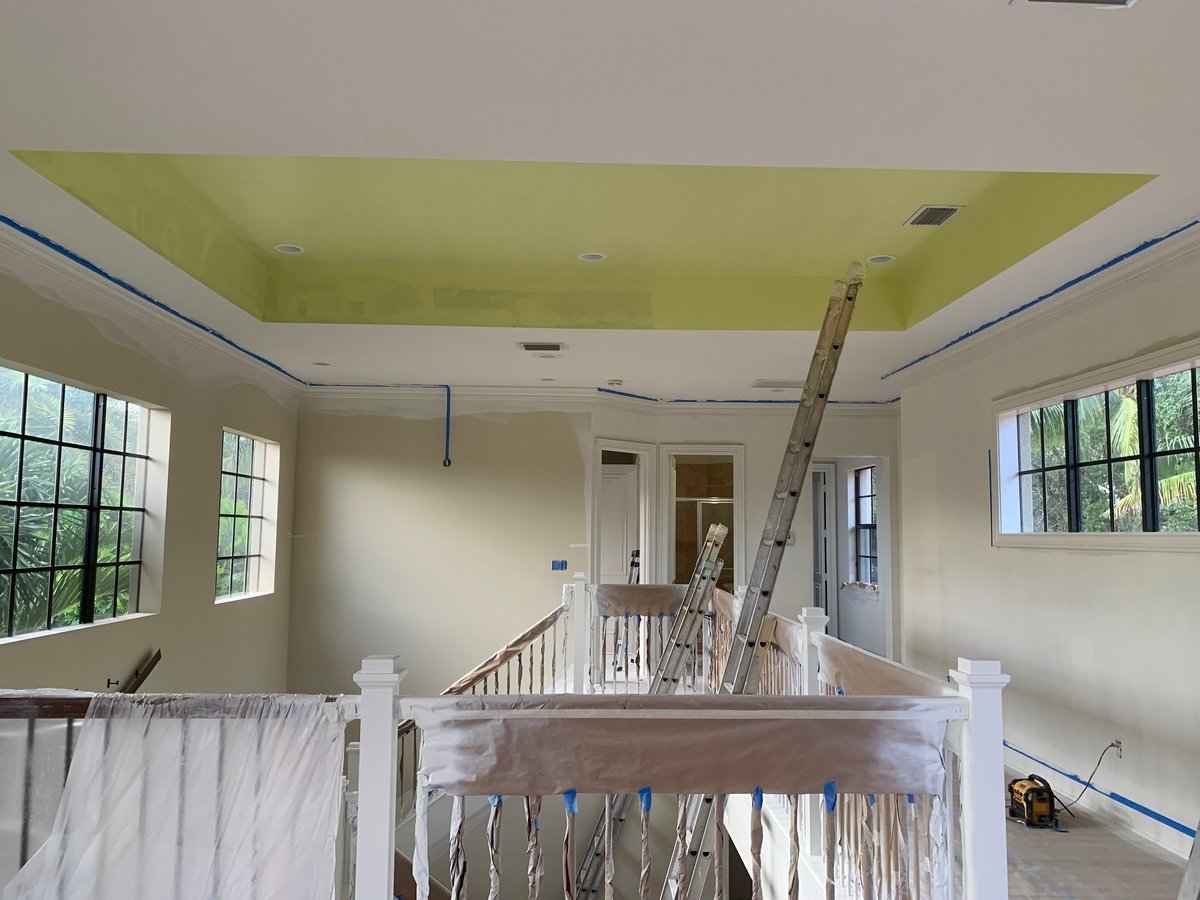 Painting the interior of a home with a high ceiling and balcony