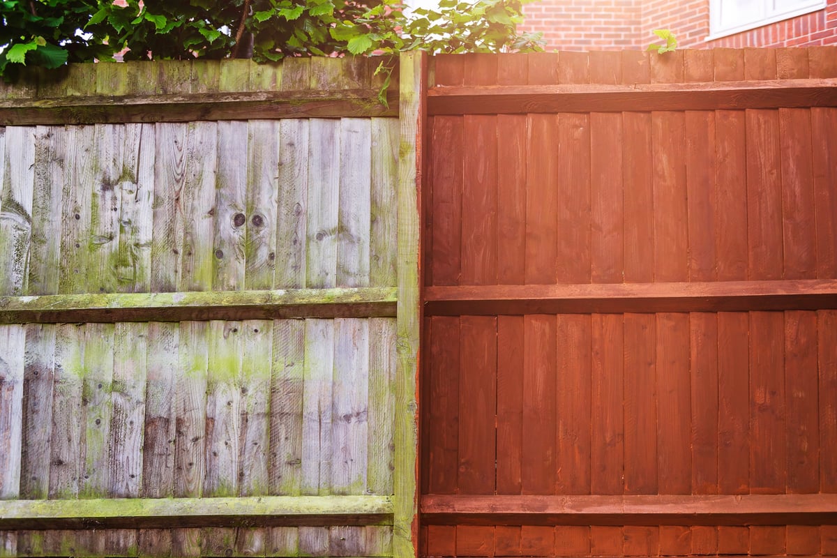 Richly stained wood fence boards showing even, protective color in bright sunlight