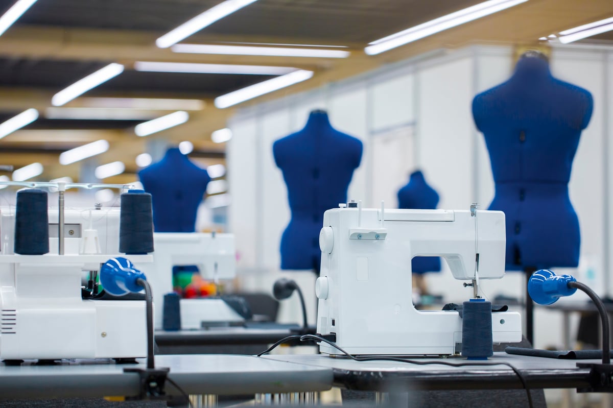 Interior de fábrica de confección con máquinas de coser