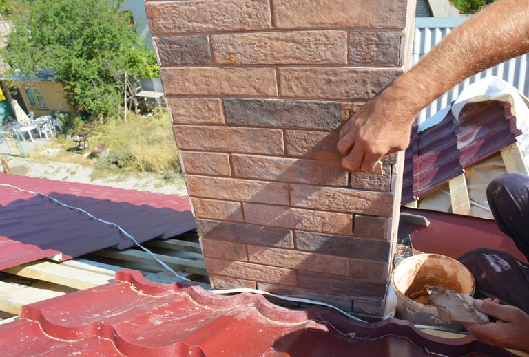 Roofer repairing chimney pipe and smoke stack on a metal roofing construction
