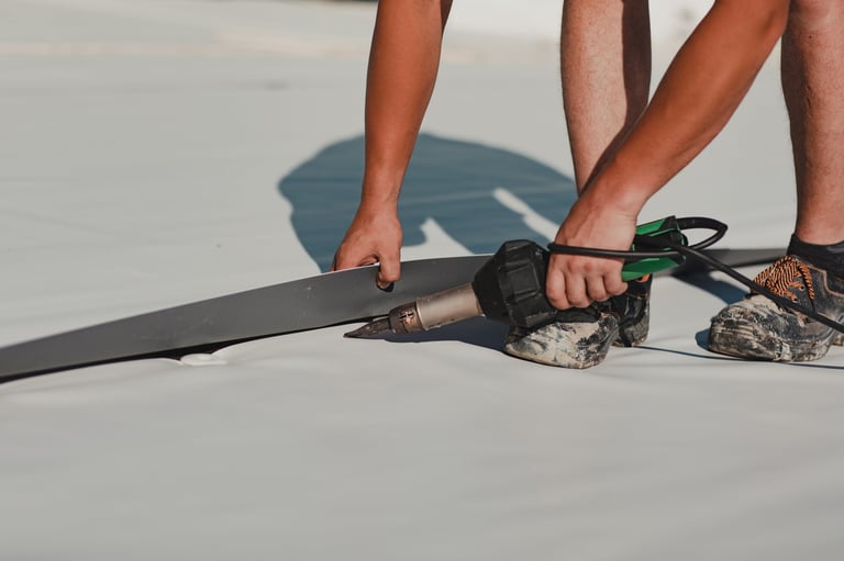 Worker welding pvc roof membrane by heater with welder machine