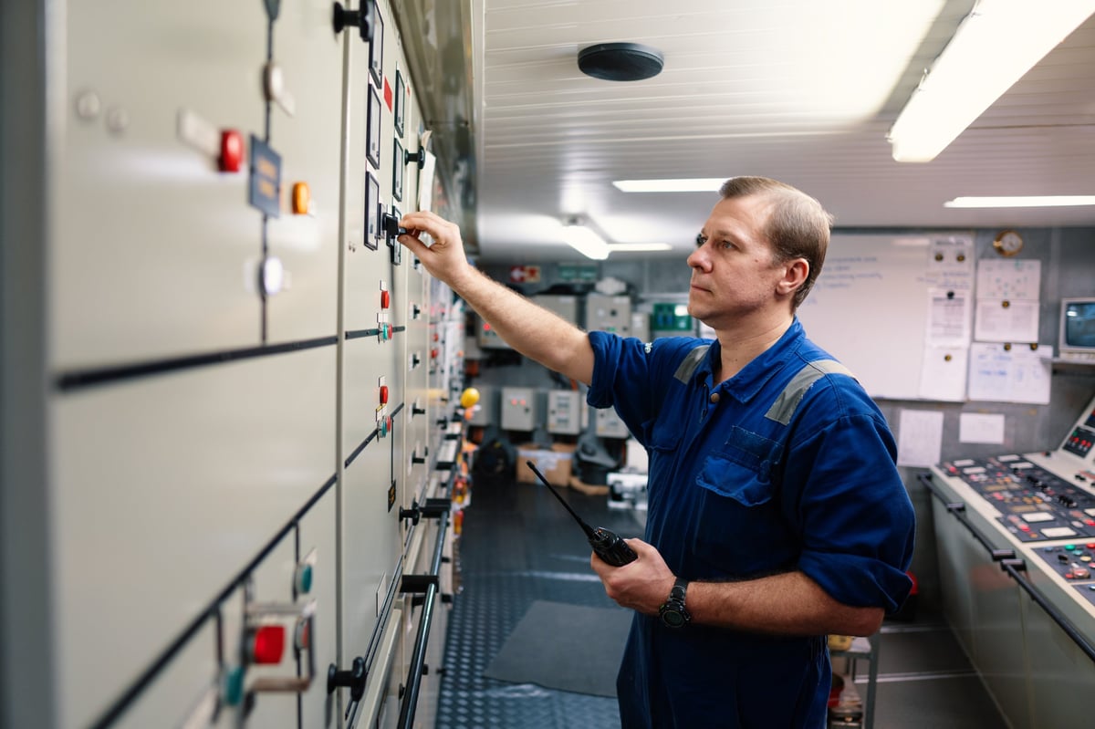 Marine engineer officer controlling vessel engines and propulsion in engine control room ECR