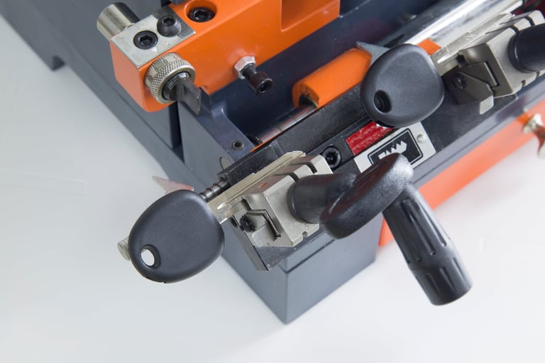 Automotive locksmith cutting a spare car key on precision key-cutting equipment