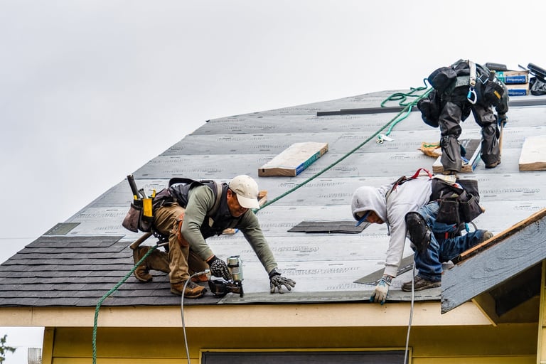 Crew installing new shingles on a roof on a rainy day in Everett, WA