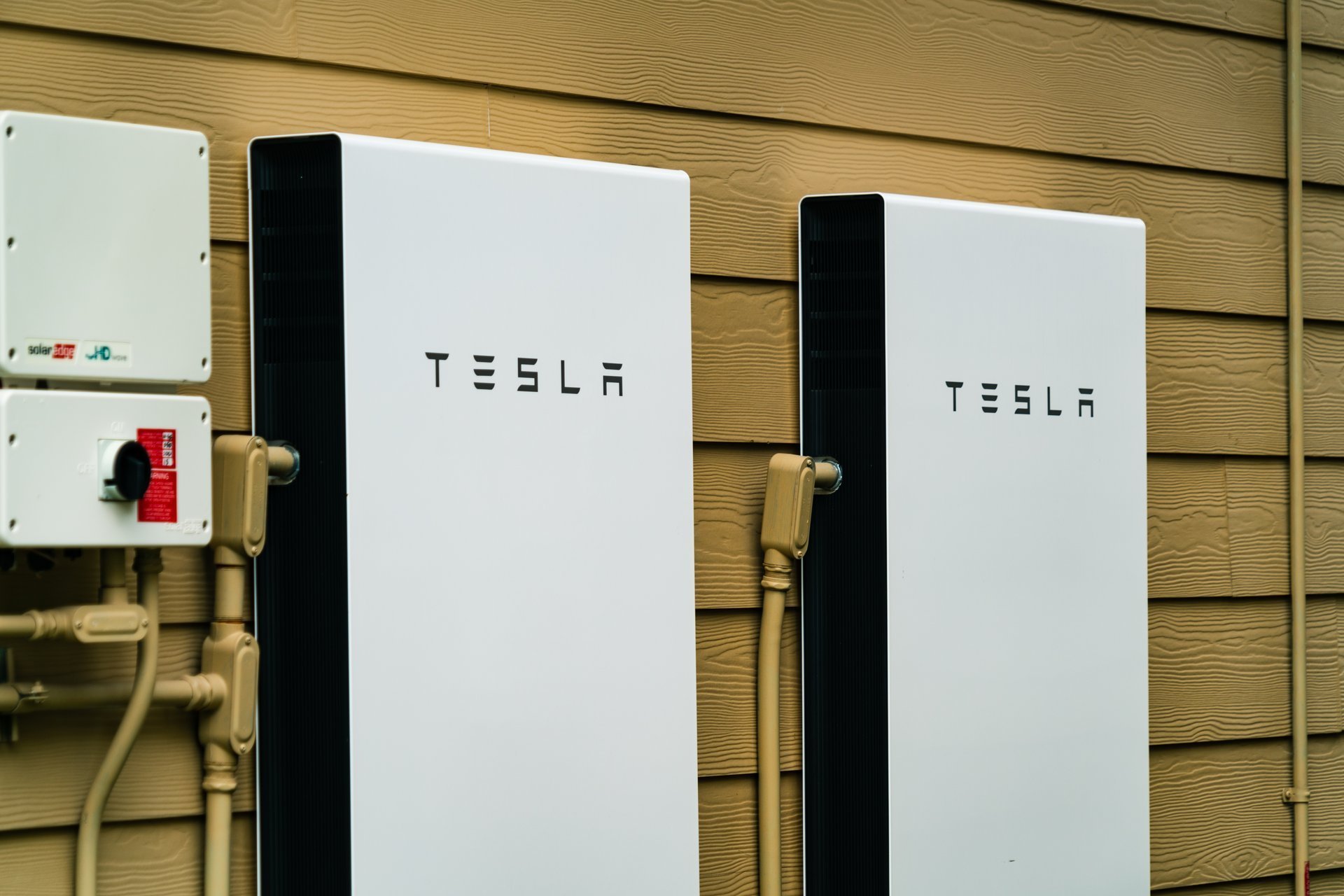 Tesla Powerwall home battery backup units installed on the side of a house — Dylco Electric battery backup installation in Westfield, IN