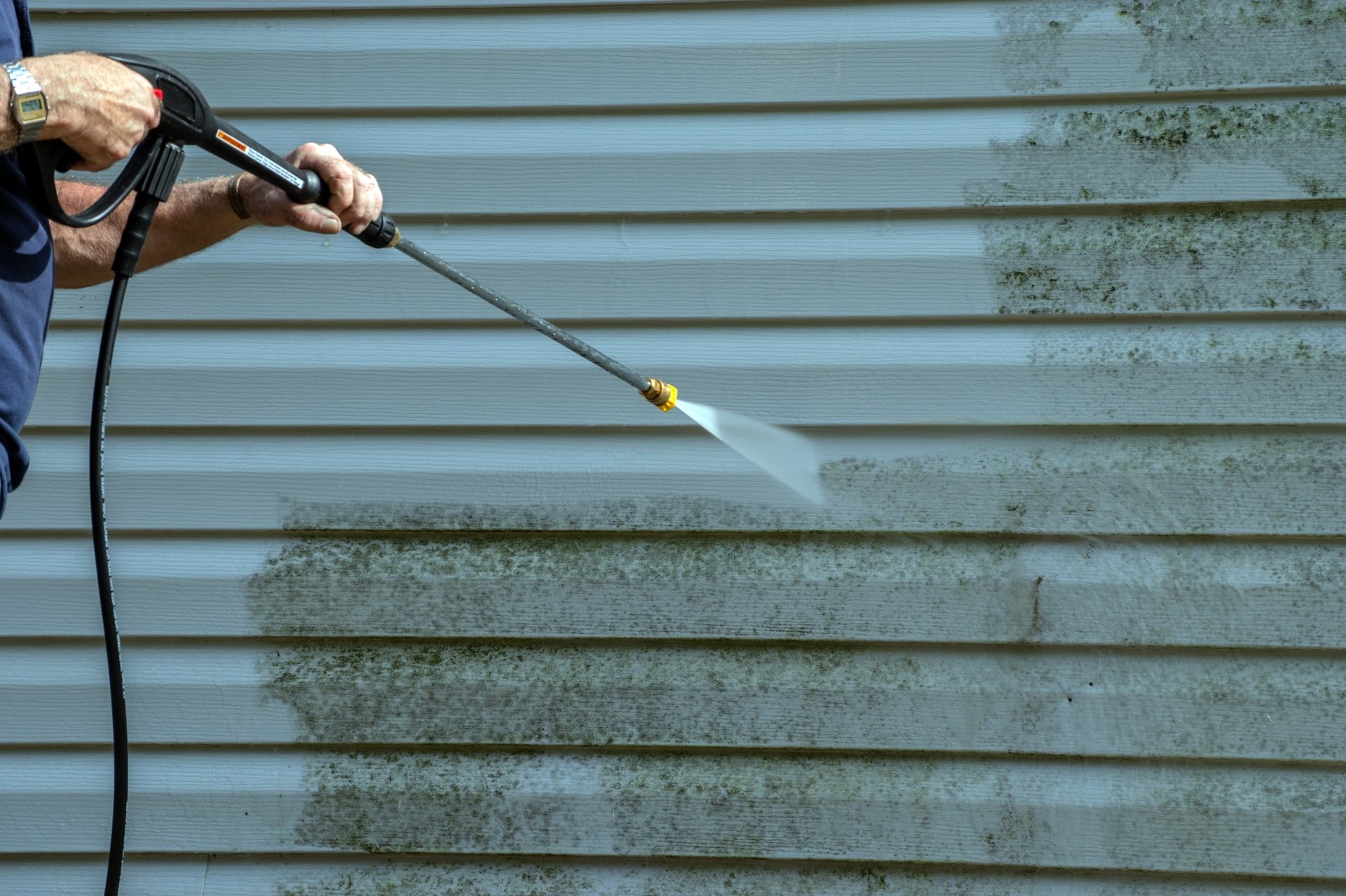 Mold and mildew being cleaned from a home exterior