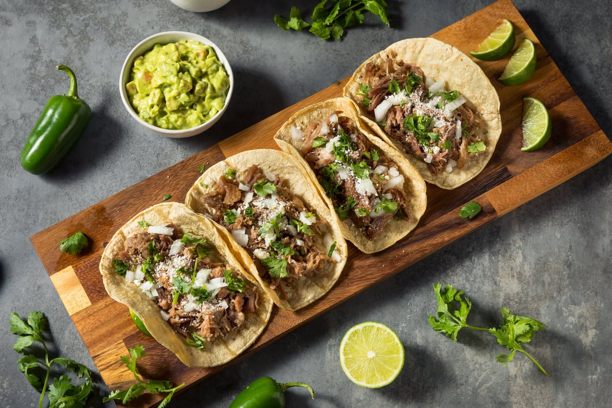 Tacos de carnitas con cilantro y cebolla