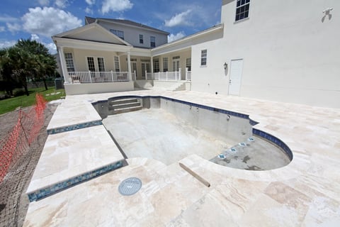Swimming pool under construction in residential backyard