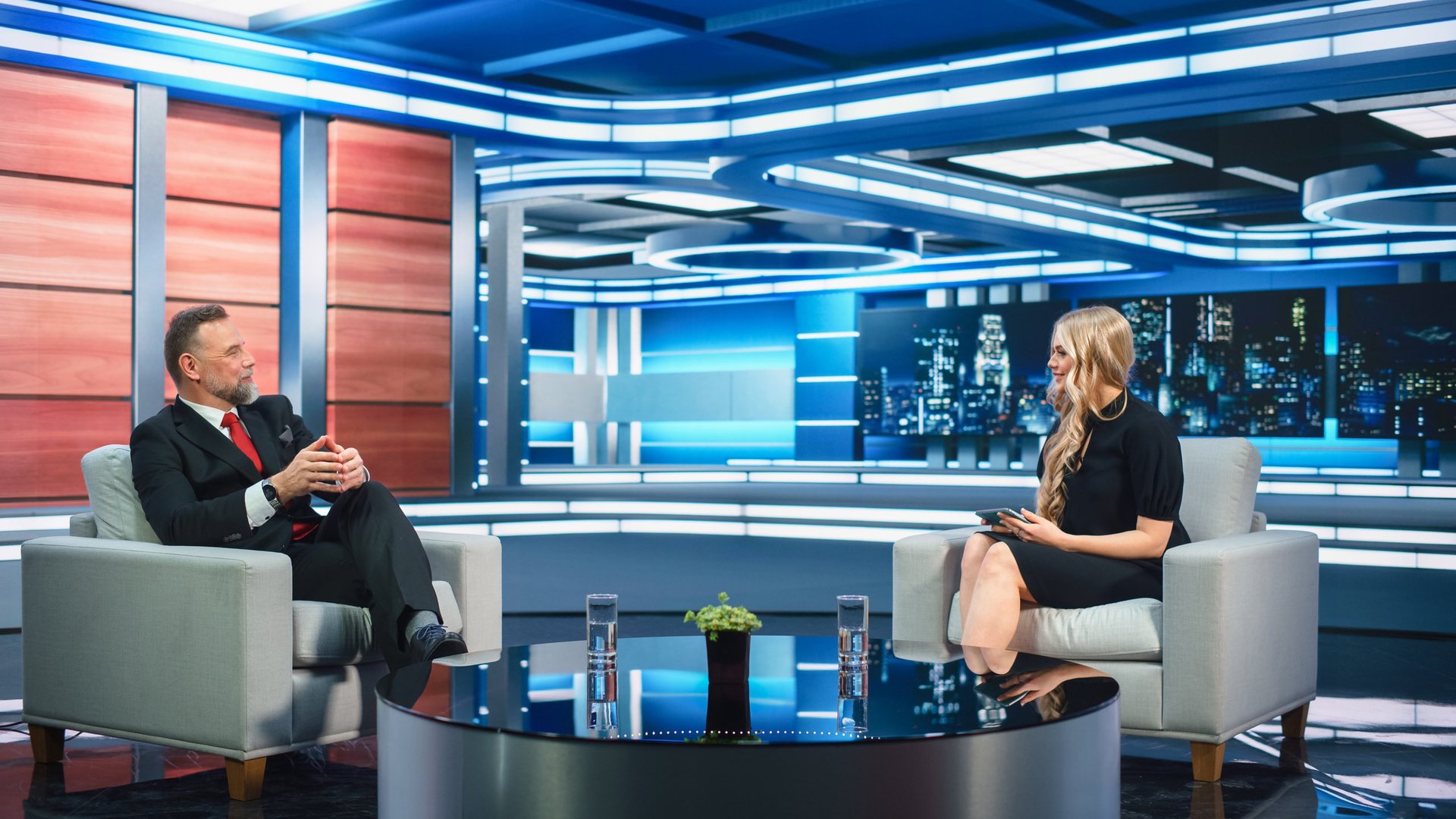 Entrevista en un estudio de televisión con presentador y vocero corporativo