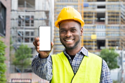Construction worker using mobile phone app on jobsite