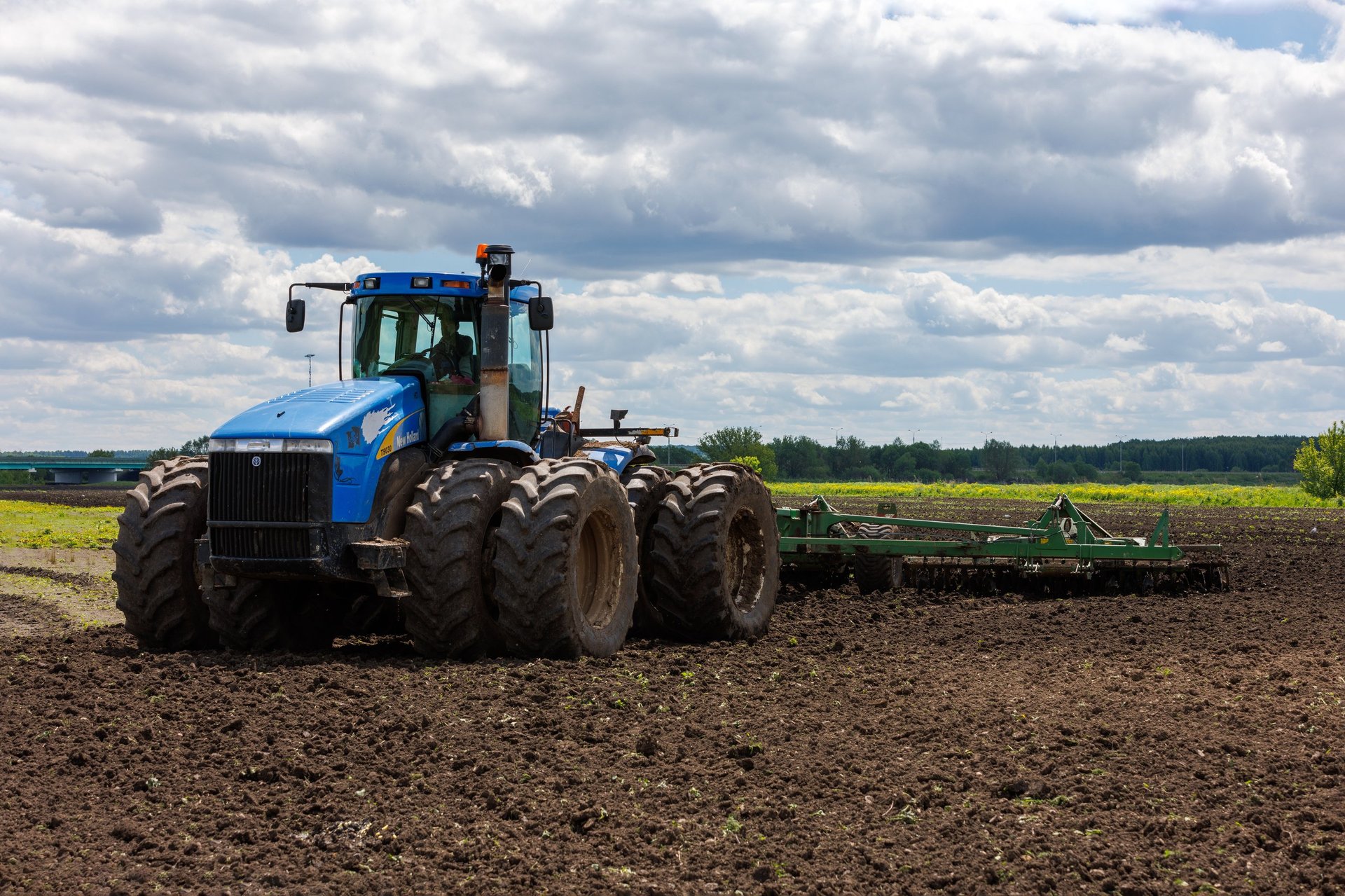 New Holland tractor with double wheels in field