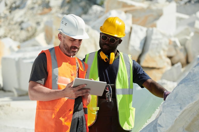 Mine safety professionals reviewing safety data on tablet