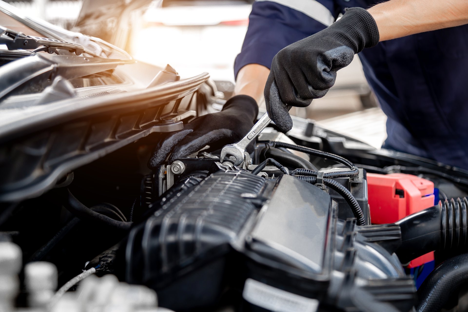 Auto mechanic using a wrench to service a car engine
