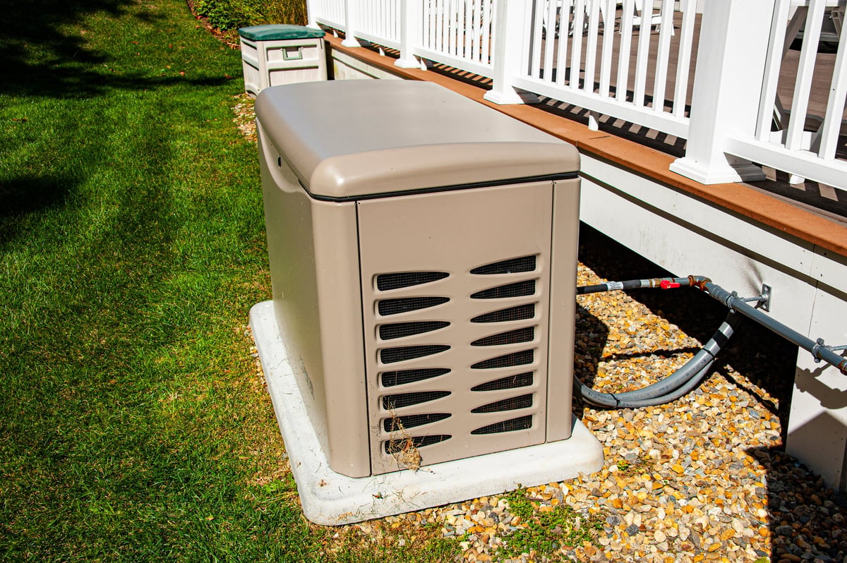 Residential whole-home standby generator installed on a concrete pad outside a home
