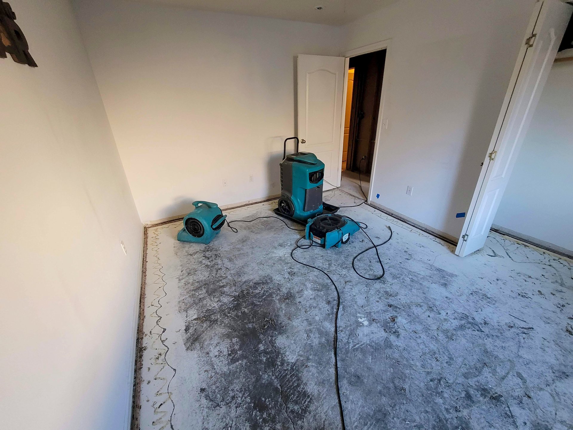 Water damaged bedroom with carpet removed and professional drying equipment