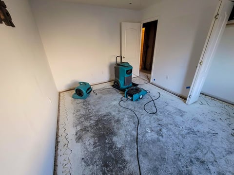 Water damaged bedroom with carpet removed and professional drying equipment