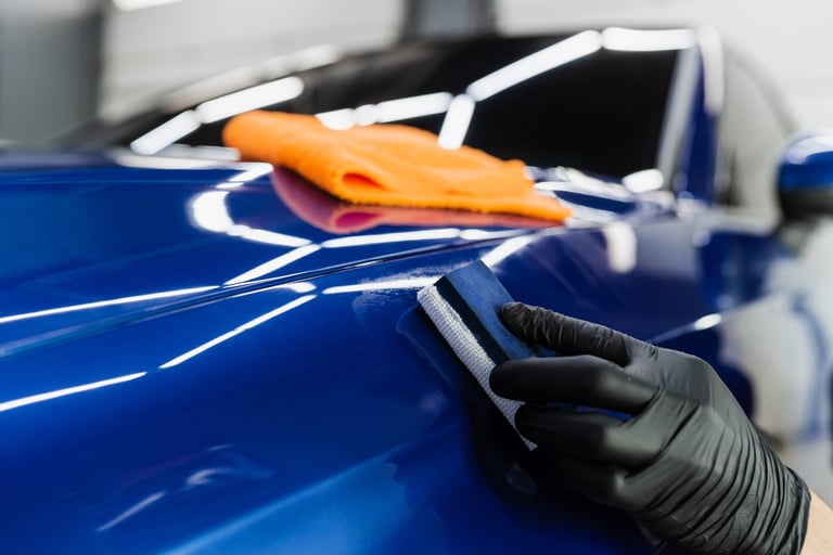 Applying a ceramic protective coat to a car body with a sponge applicator in a detailing studio — KJAJ Details ceramic coating