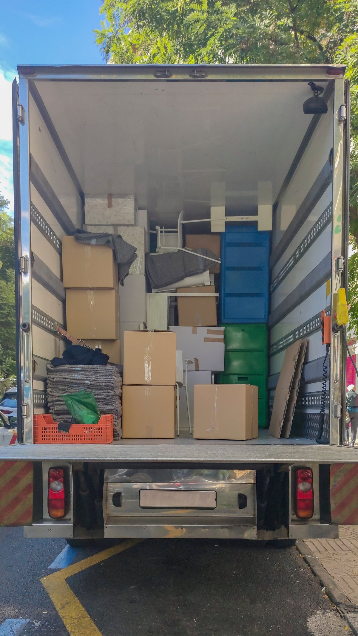 Semi-trailer moving truck loading goods at downtown street equipped with lift ramp