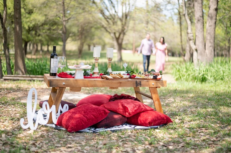 Romantic couple's picnic with candles and florals in a garden setting