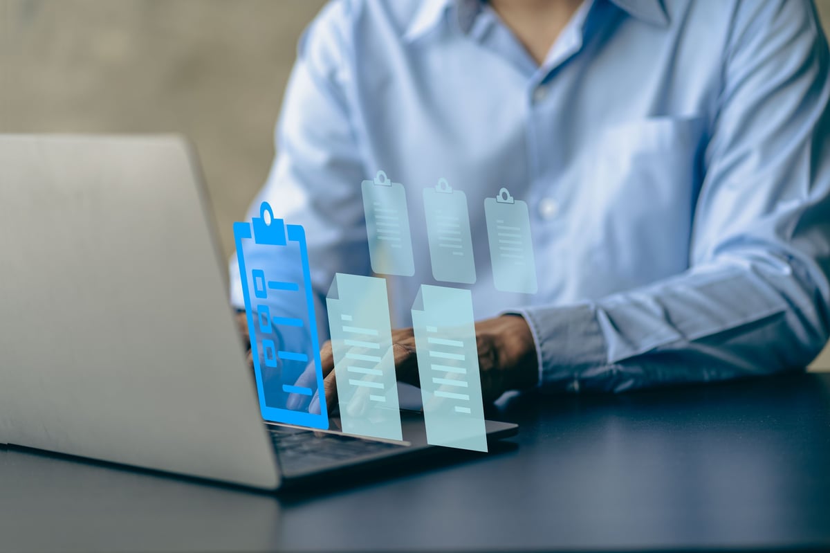 Office worker reviewing document costs on a laptop — assessing the total cost of an organisation's printing setup