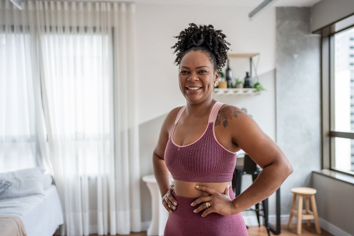 A young woman stretching at home, healthy and at ease