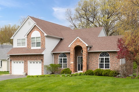 Suburban brick and vinyl home with two-car garage after full exterior repaint with Sherwin-Williams Latitude Exterior paint in Plano TX by Prime Finish Painting Co.