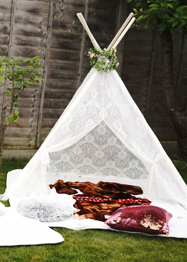 Whimsical teepee birthday party setup with balloons and pastel decorations