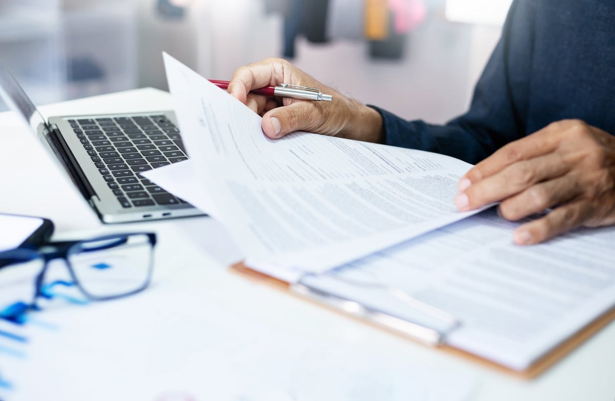 Taycan Advisors senior advisor reviewing tax legal recovery documents and financial reports with business executive