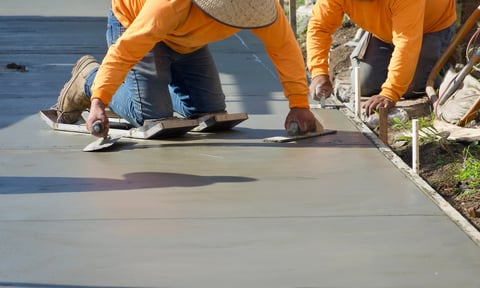 Construction workers finishing freshly poured concrete