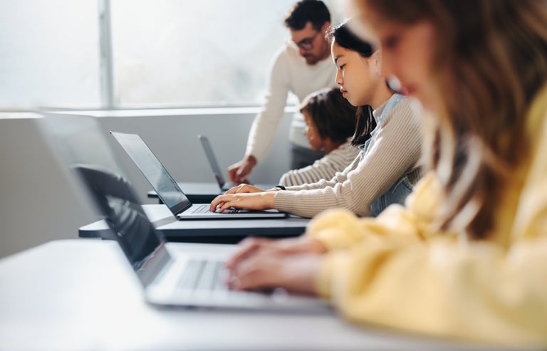 Teacher helping children with coding exercises