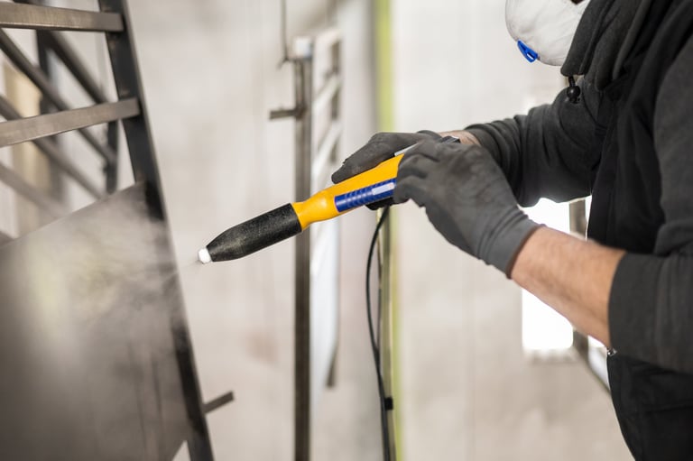 Aplicación de pintura electrostática con pistola electrostática en pieza metálica