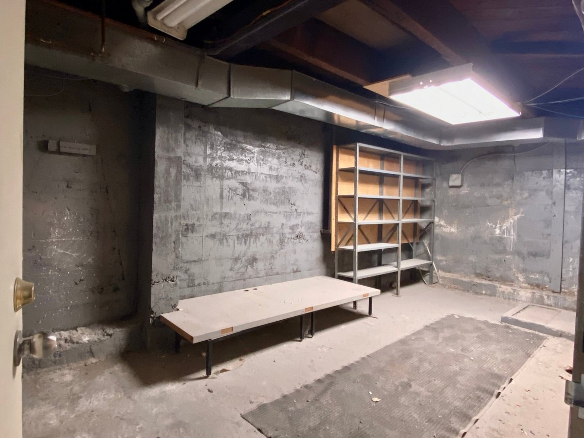 Empty basement storage room demolished with cement walls and cement floors