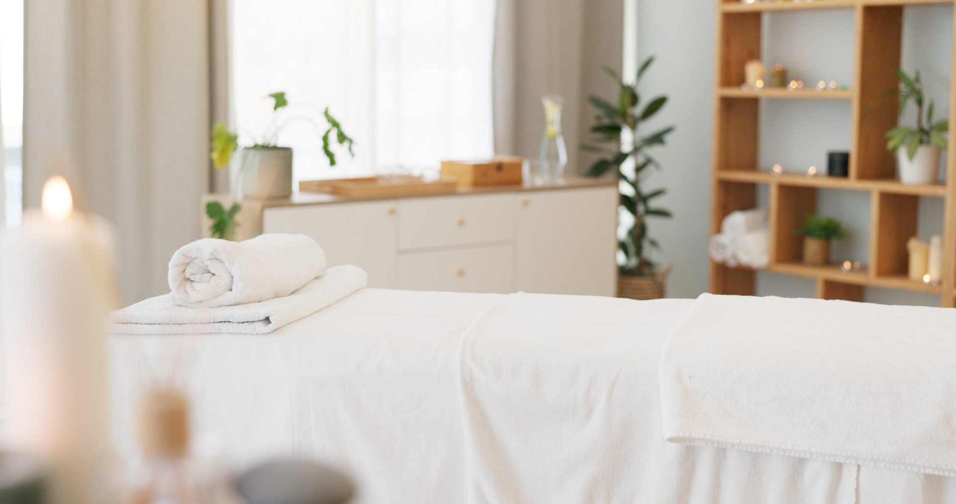 Serene spa treatment room with candles and neutral tones