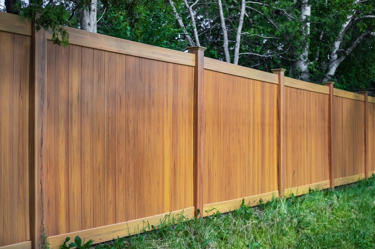 Nice new wooden fence around house with green lawn