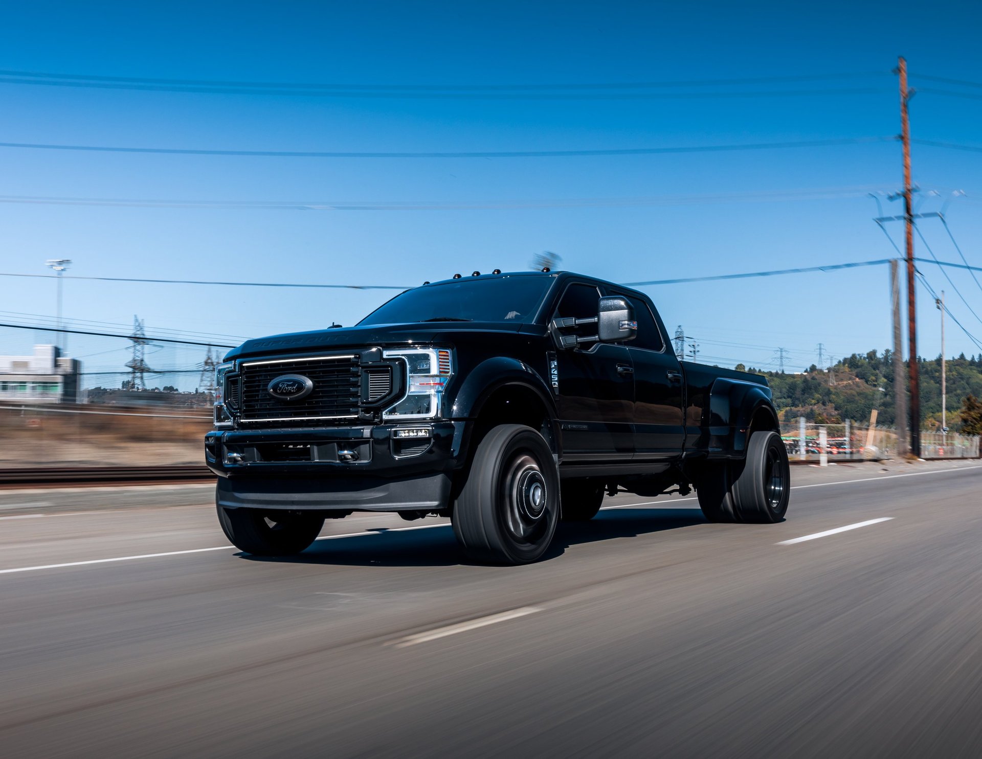 A black Ford F450 pickup driving on the highway, the kind of work truck CBB Group arranges financing for