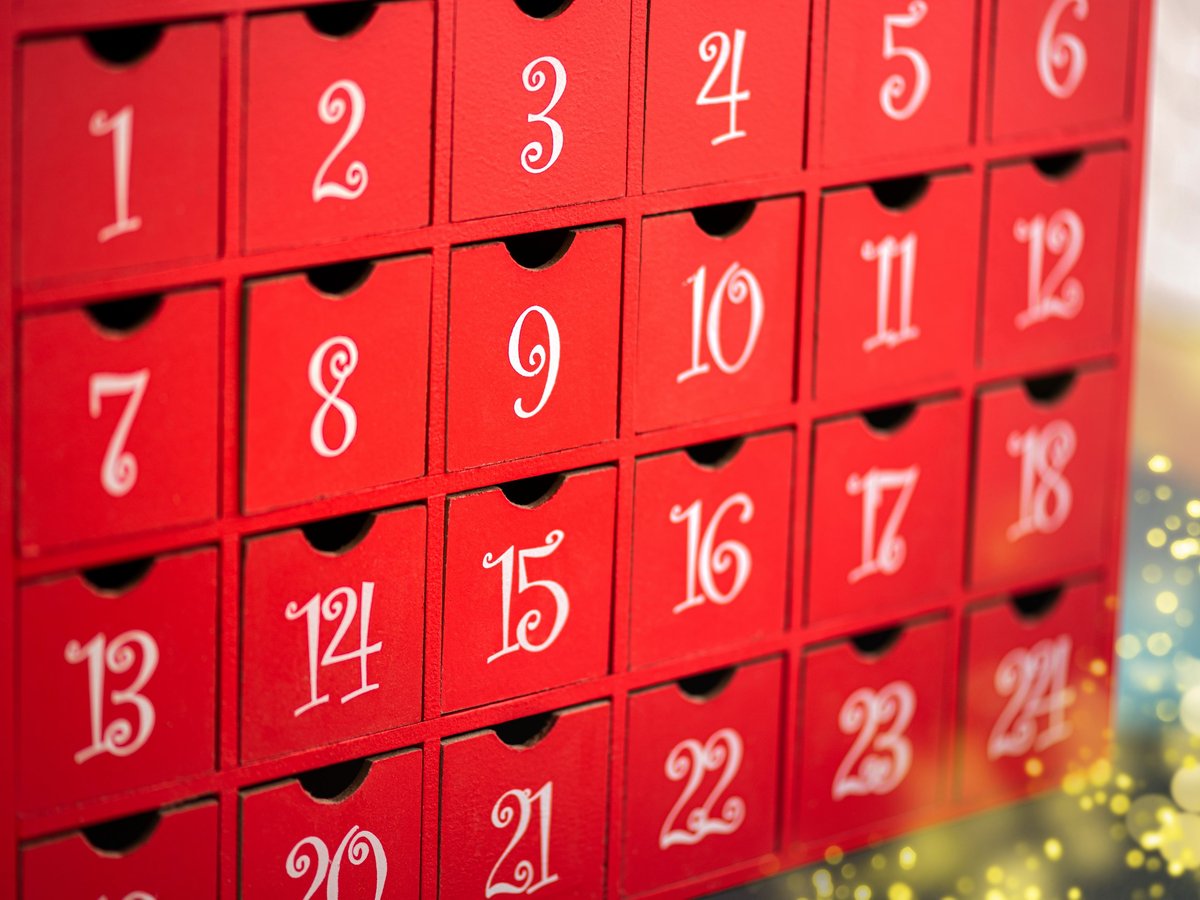 Red advent calendar with 24 numbered doors and Christmas decorations