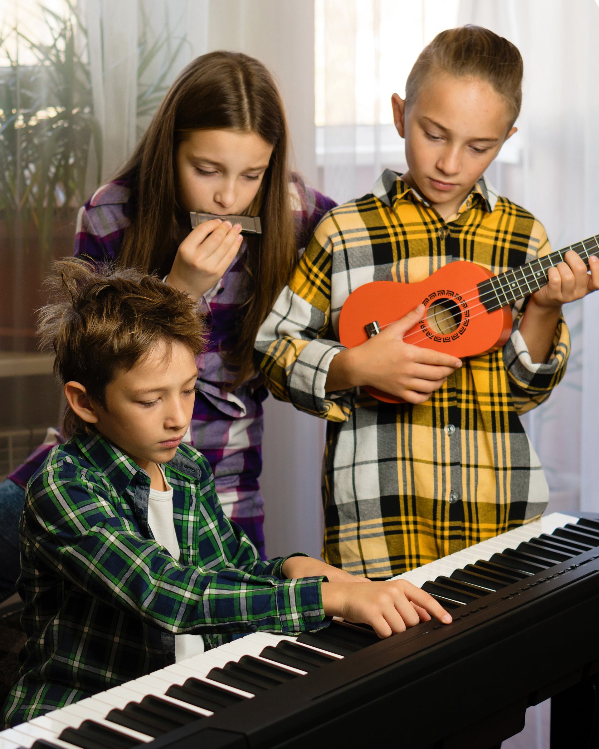 Three children playing different instruments — harmonica, ukulele, and piano — in a cozy room