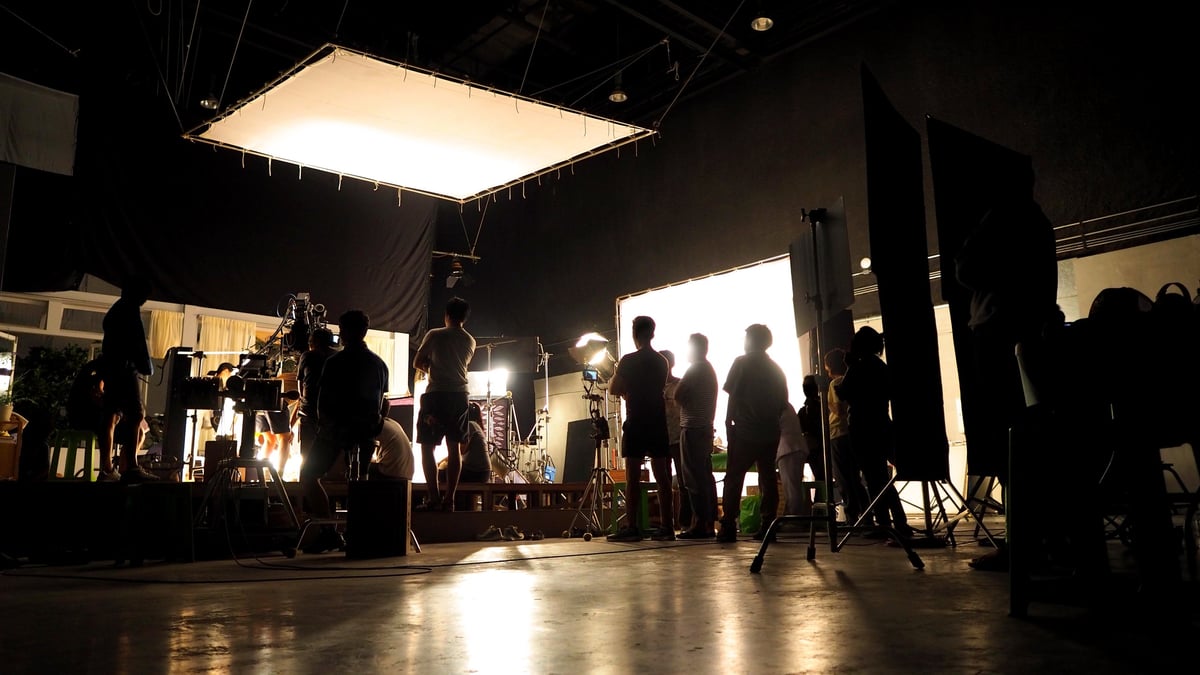 Équipe de tournage en silhouette avec équipement de caméra en studio