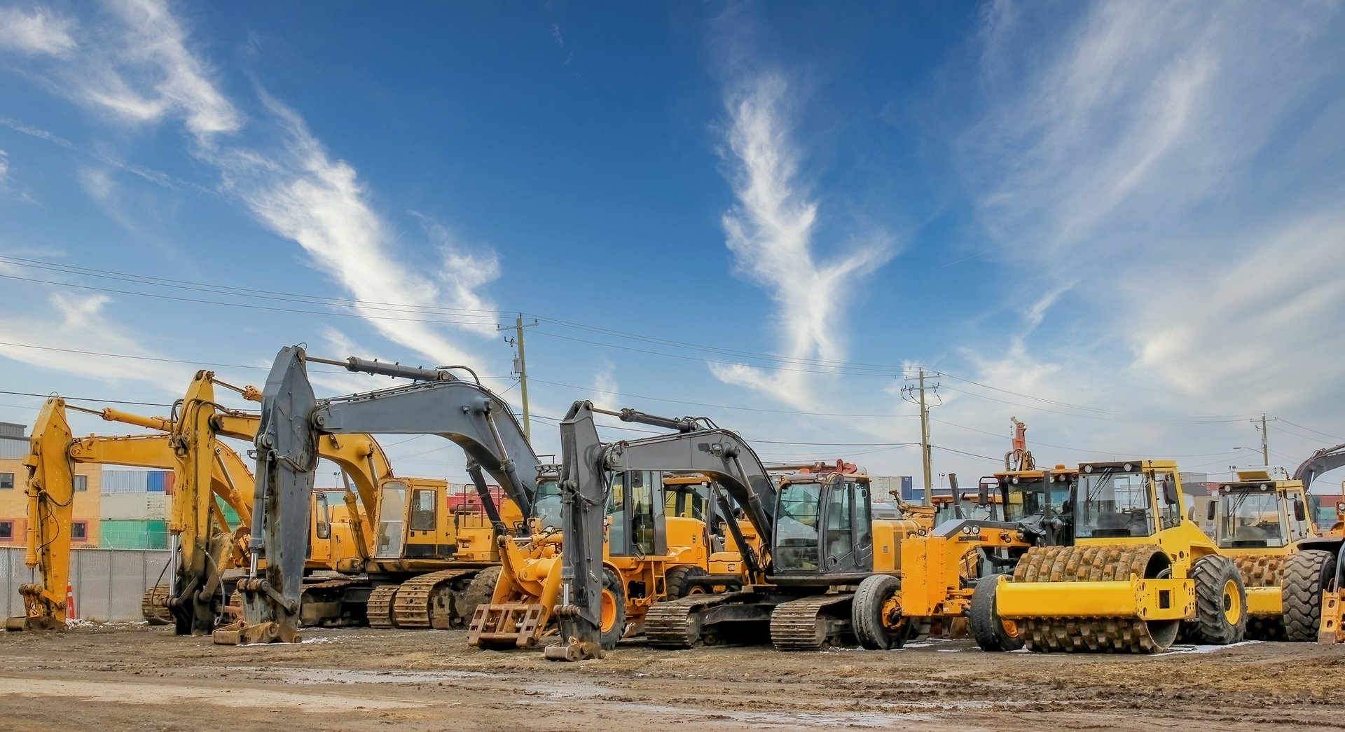 Excavators, bulldozers and earthmovers lined up at a construction site in winter