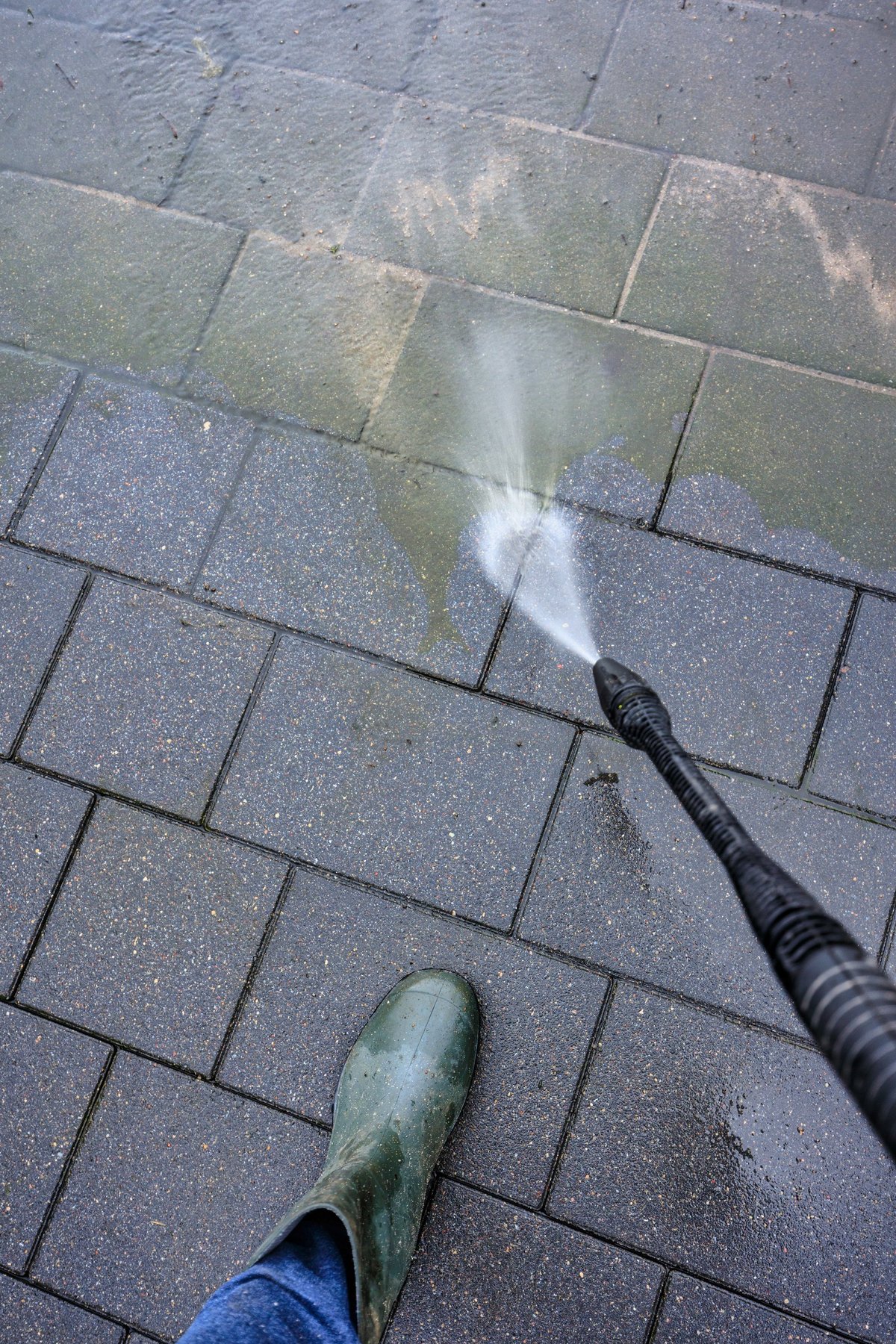 Spring cleaning of a house driveway with a pressure washer