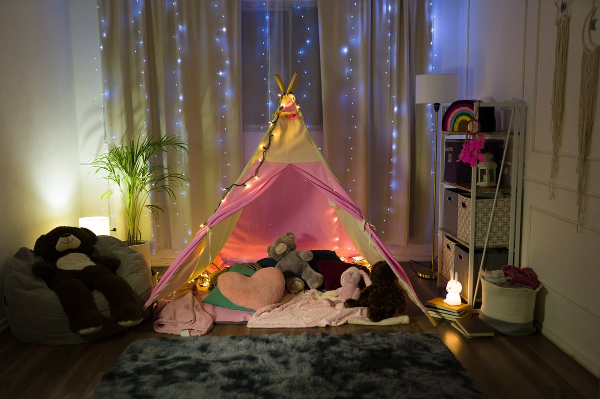 Enchanting teepee sleepover setup with fairy lights, soft bedding, and whimsical pastel decorations