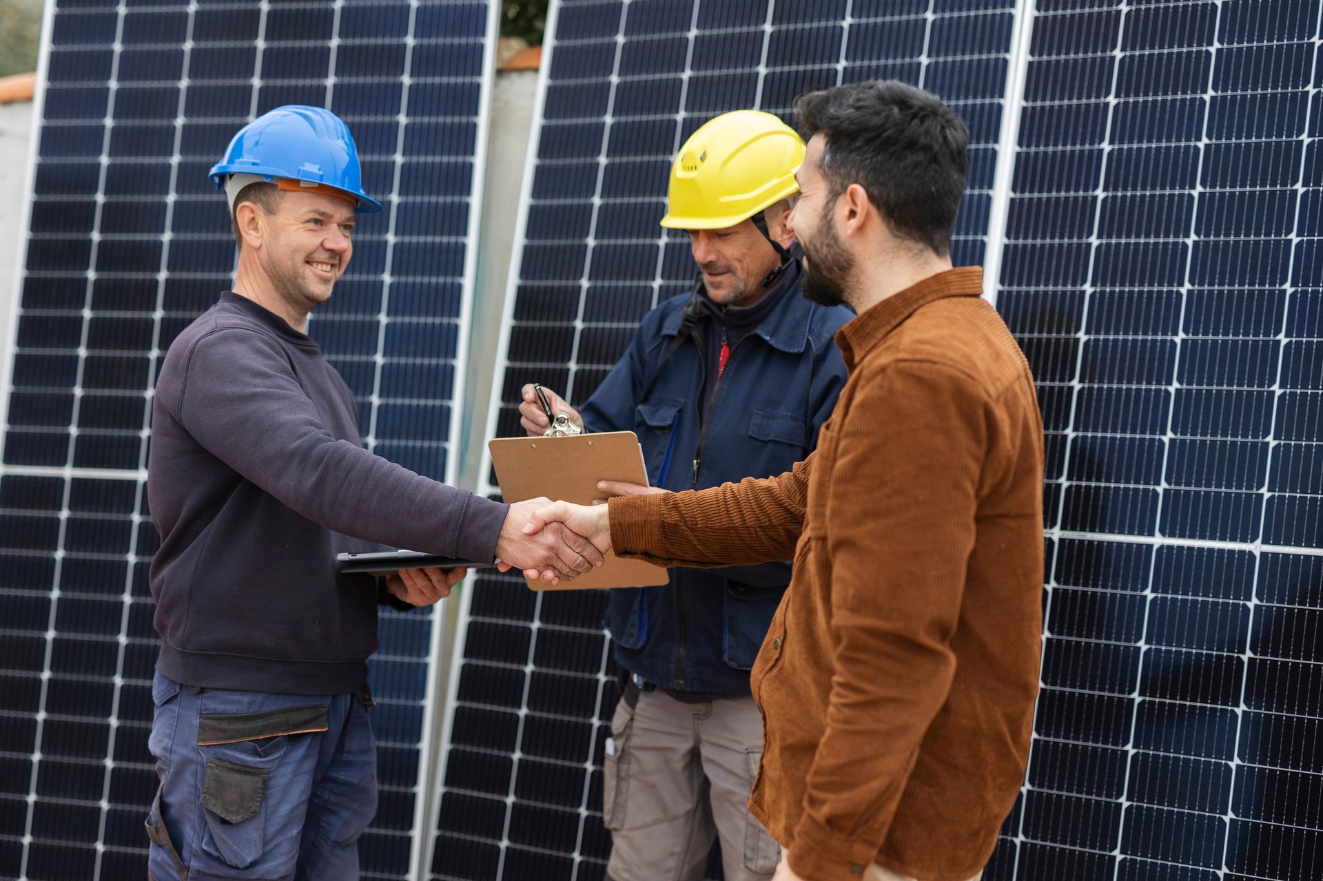 Businessman and engineers shake hands, acquiring solar panels and closing agreement
