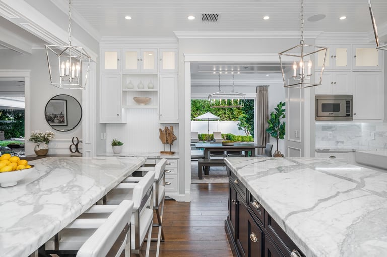 Marble kitchen with white island and chairs in new construction