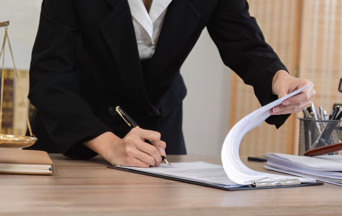 Professional notary signing documents with client in modern office setting