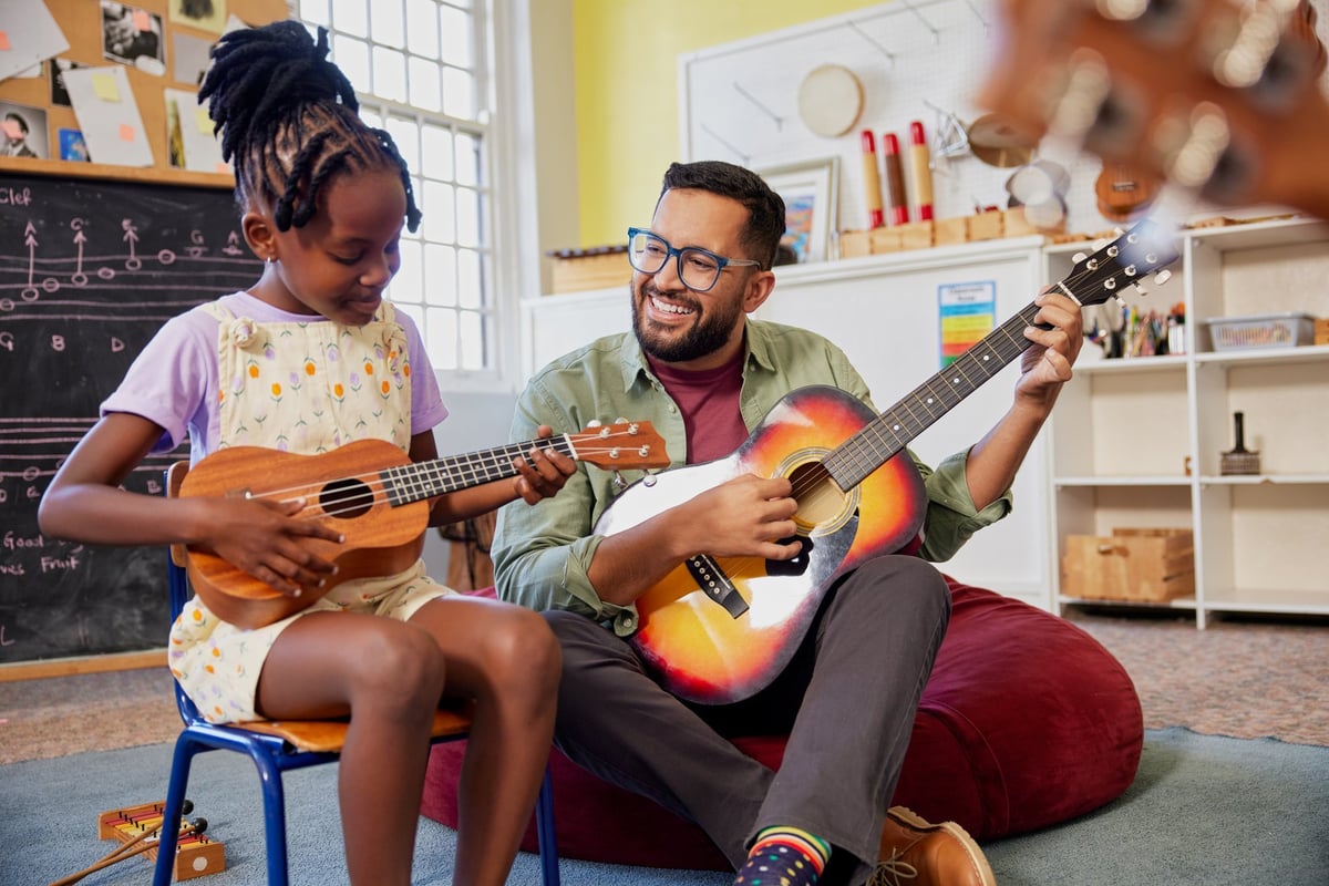 Teacher helping student learn guitar