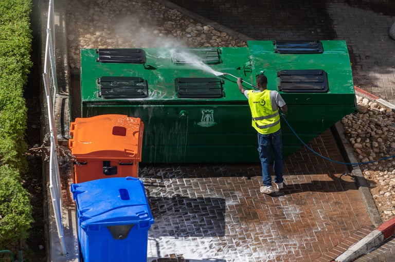 Worker sanitizing trash bins