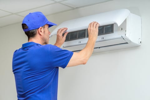 HVAC technician servicing air conditioning unit